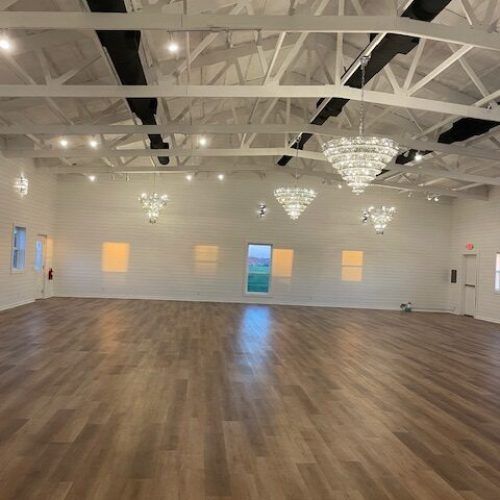 The empty ballroom with chandeliers and an open wood floor
